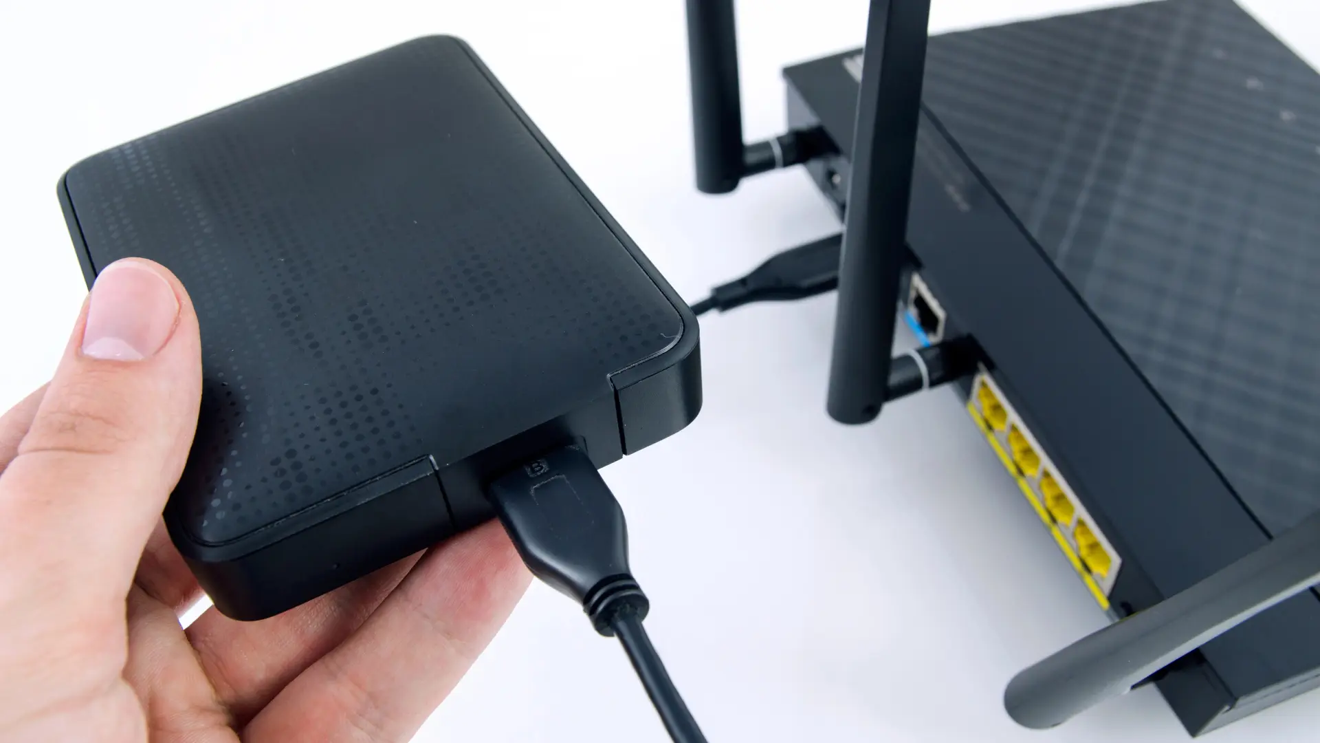 Imagen de un router con un disco duro externo conectado al puerto USB, listo para compartir archivos en la red