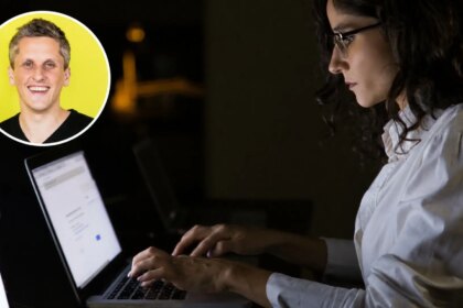 Un directivo mirando fijamente una pantalla de computadora con una imagen de robot 'pensativo' detrás