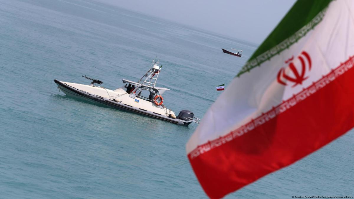 Imagen de un buque de guerra en el estrecho de Ormuz, con la bandera de Irán en el fondo