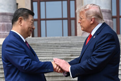 Donald Trump y Xi Jinping en una reunión bilateral, sonriendo y estrechando manos