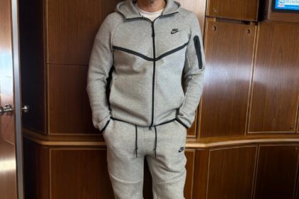 Marco Rubio sonriendo en el Air Force One con una sudadera gris Nike Tech Fleece