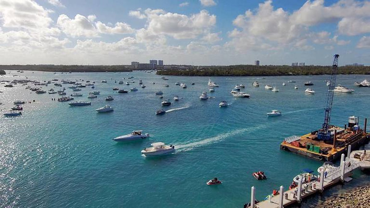 Barco en el mar con una columna de humo saliendo de él, cerca de la costa de Miami
