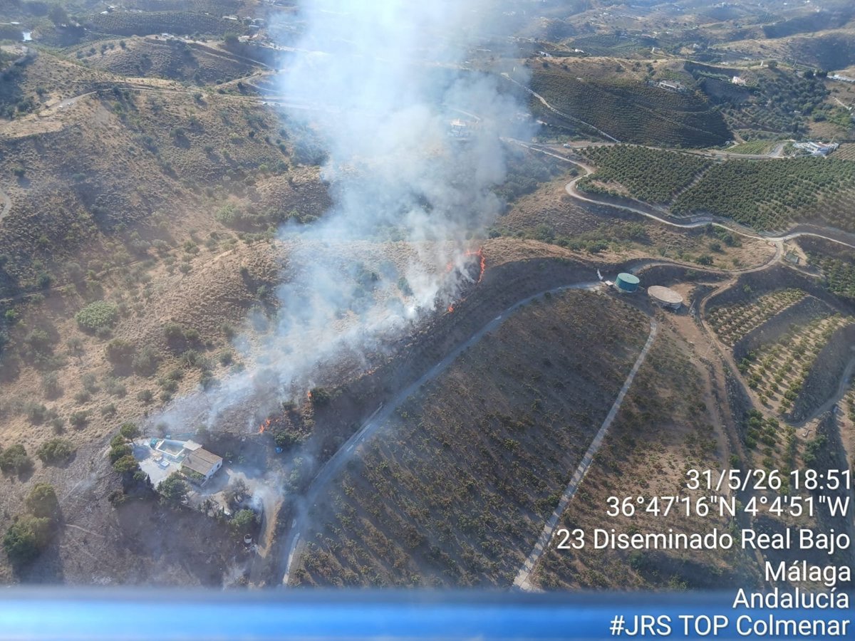 Helicóptero ligero sobrevolando zona de incendio forestal en Vélez-Málaga