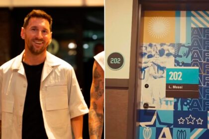 Lionel Messi sonriendo en su habitación de hotel con el número 202 en la puerta