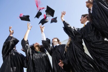 Estudiantes protestando en una graduación universitaria contra el uso de IA en diplomas y chaquetas de promoción