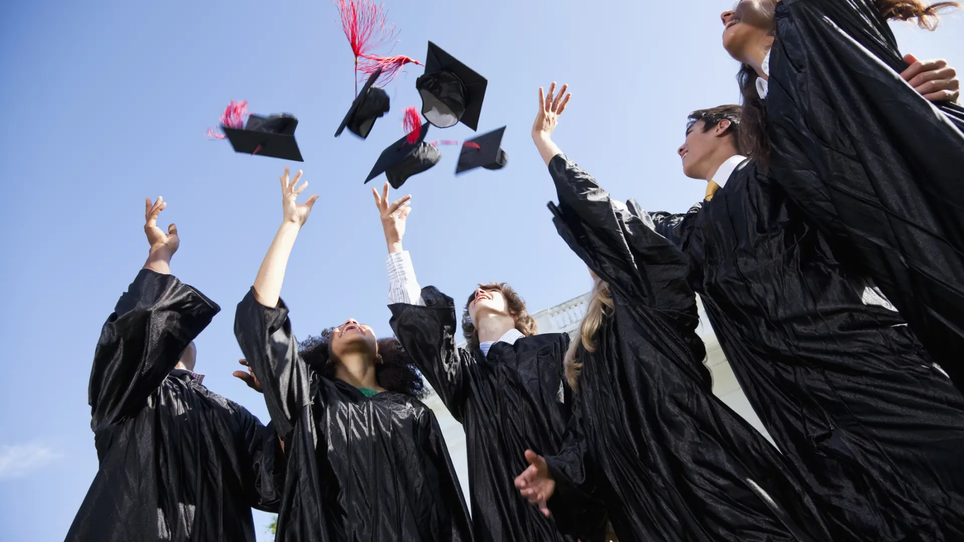 Estudiantes protestando en una graduación universitaria contra el uso de IA en diplomas y chaquetas de promoción