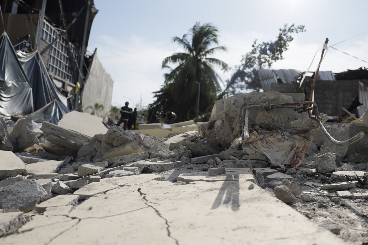 Imagen de una zona devastada por el terremoto en Filipinas con escombros y personas afectadas